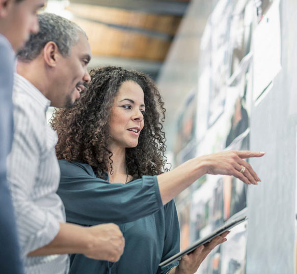 Executive Consultant standing at a board giving executive consultancy to a group of managers