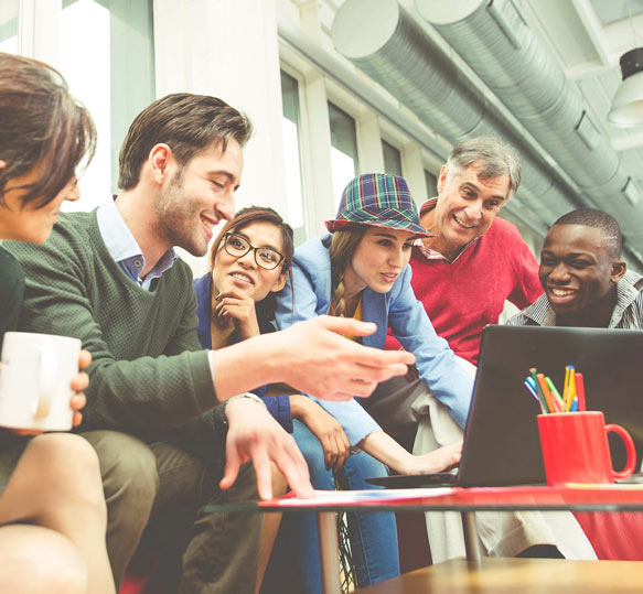 Team and Individual Effectiveness. Group of young people leaning over a computer working together as a team
